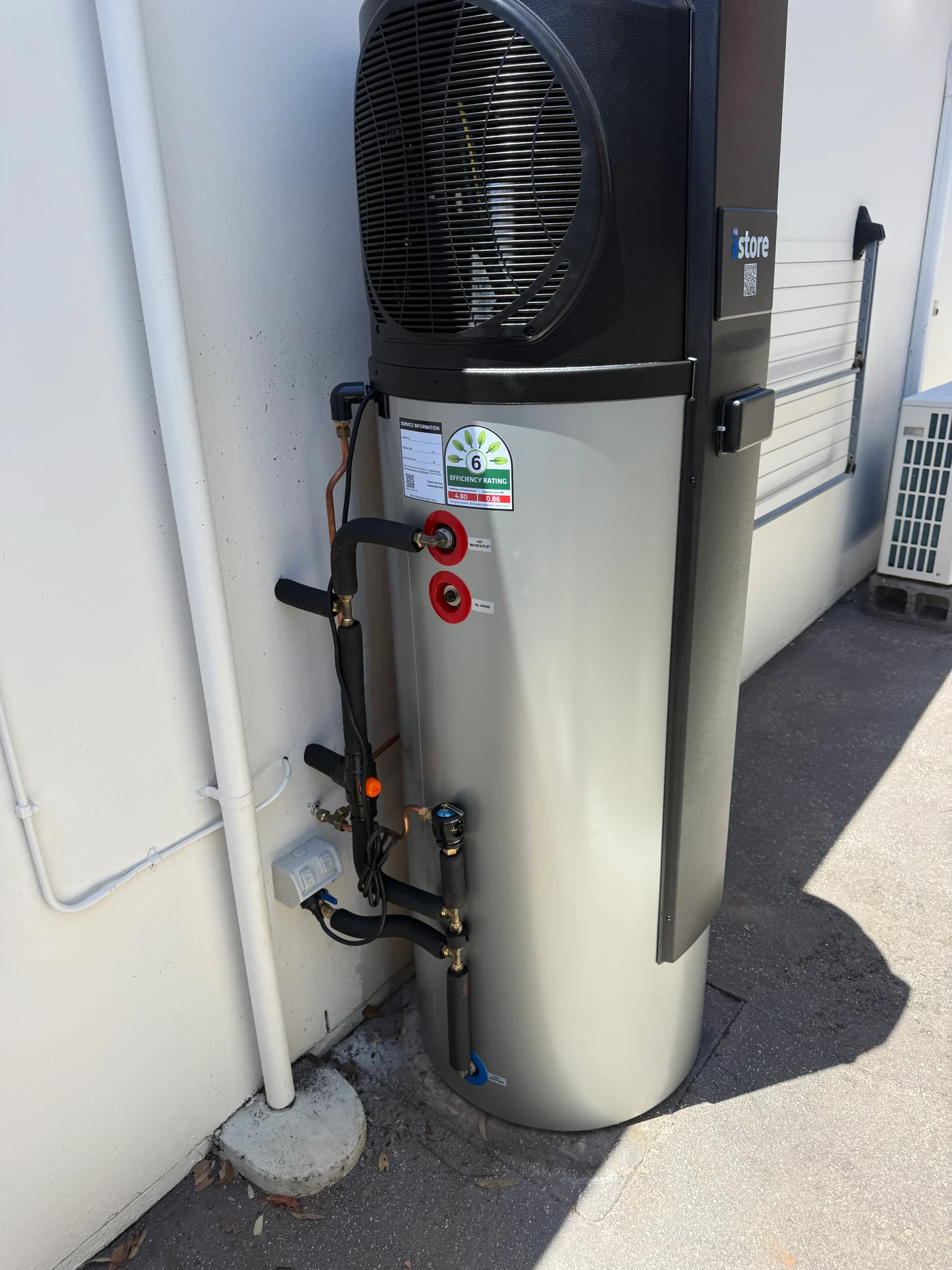 iStore heat-pump hot-water system connected beside a Brisbane home